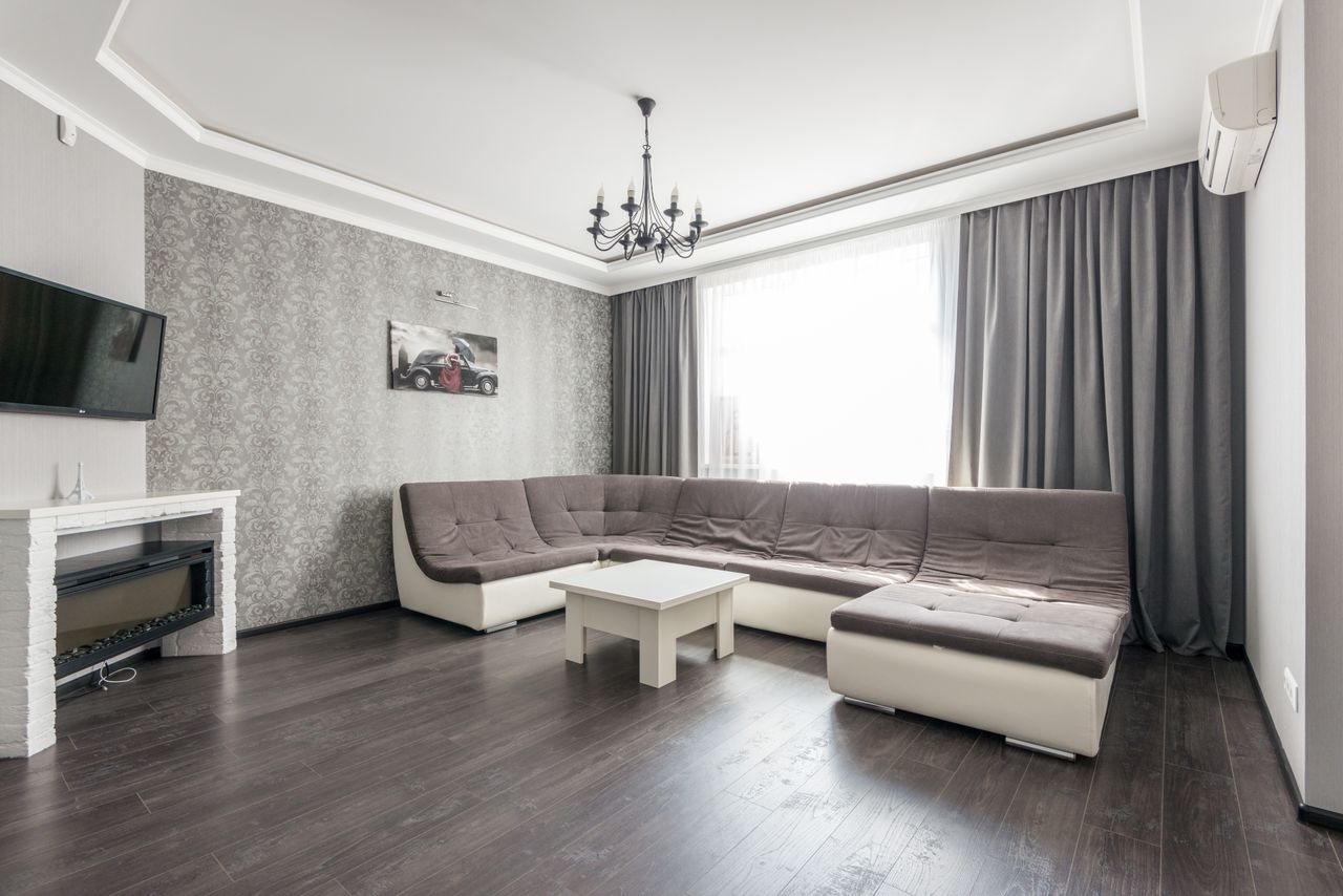 Elegant and modern living room interior featuring a large sectional sofa and natural light.
